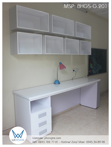 Bàn học đôi của 2 bé có tủ đồ 1 hộc - 3 ngăn kéo bên trái, tủ hộc để đồ trang trí bên phải và kệ sách treo tường kiểu hộc chữ nhật cho 2 bé ngồi cạnh nhau để học bài