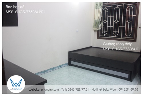 Bàn đôi vân gỗ óc chó được đặt ở tường bên trái cửa ra vào và giường 2 tầng thấp 1m4 được đặt đối diện bàn học