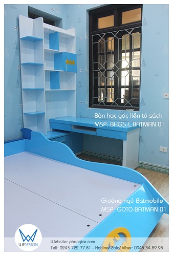 Tường bên cạnh cửa ra vào có cửa sổ nhìn ra ban công cũng là vị trí kê một bàn học góc liền tủ sách Batman